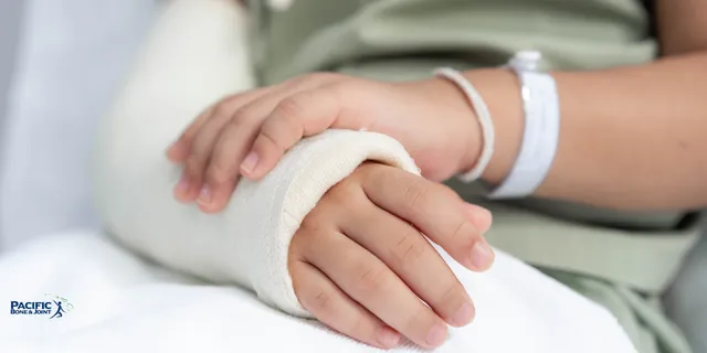 A child's forearm and hand in a cast