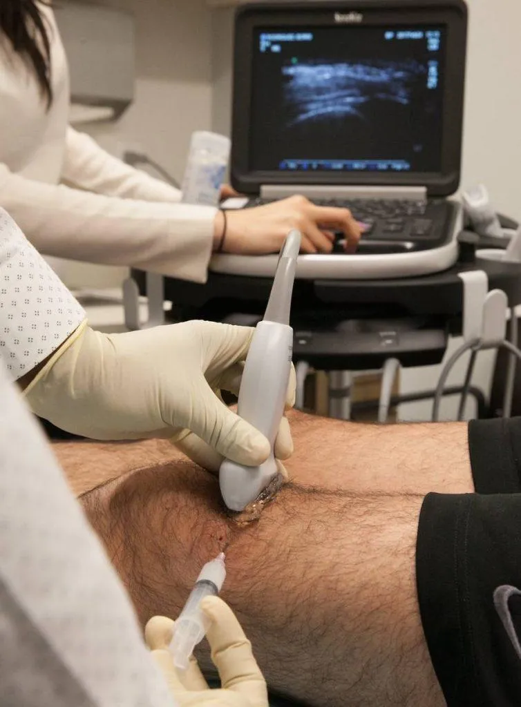 Clinician performing an ultrasound-guided knee injection